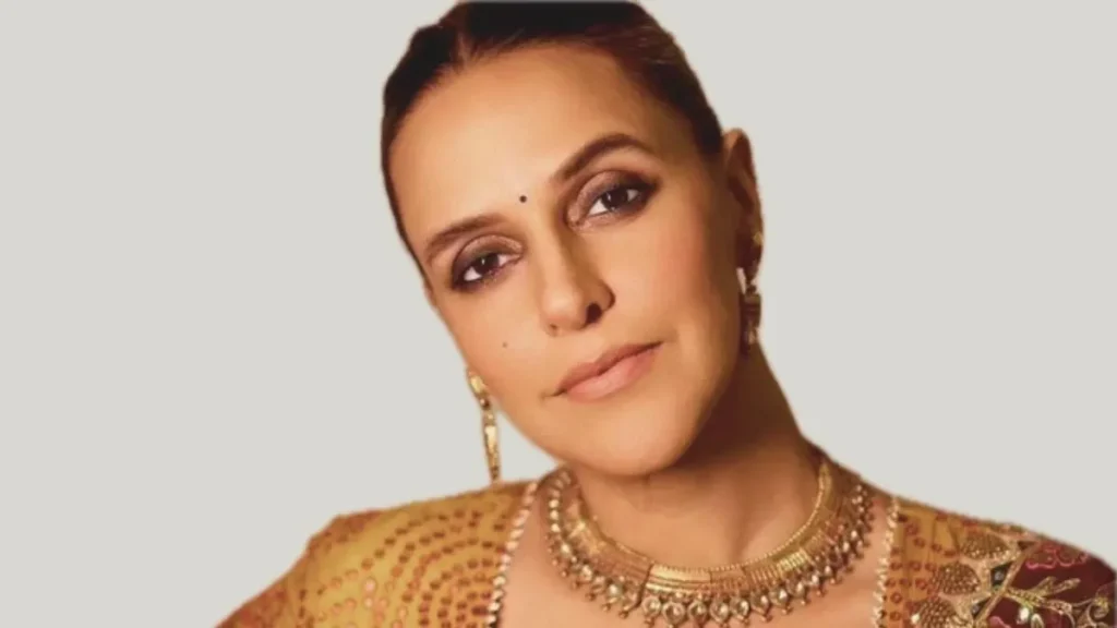 Neha Dhupia Controversy in Traditional Indian Jewelry Neha Dhupia wearing traditional Indian jewelry, including a gold necklace and earrings, with a blurred face.