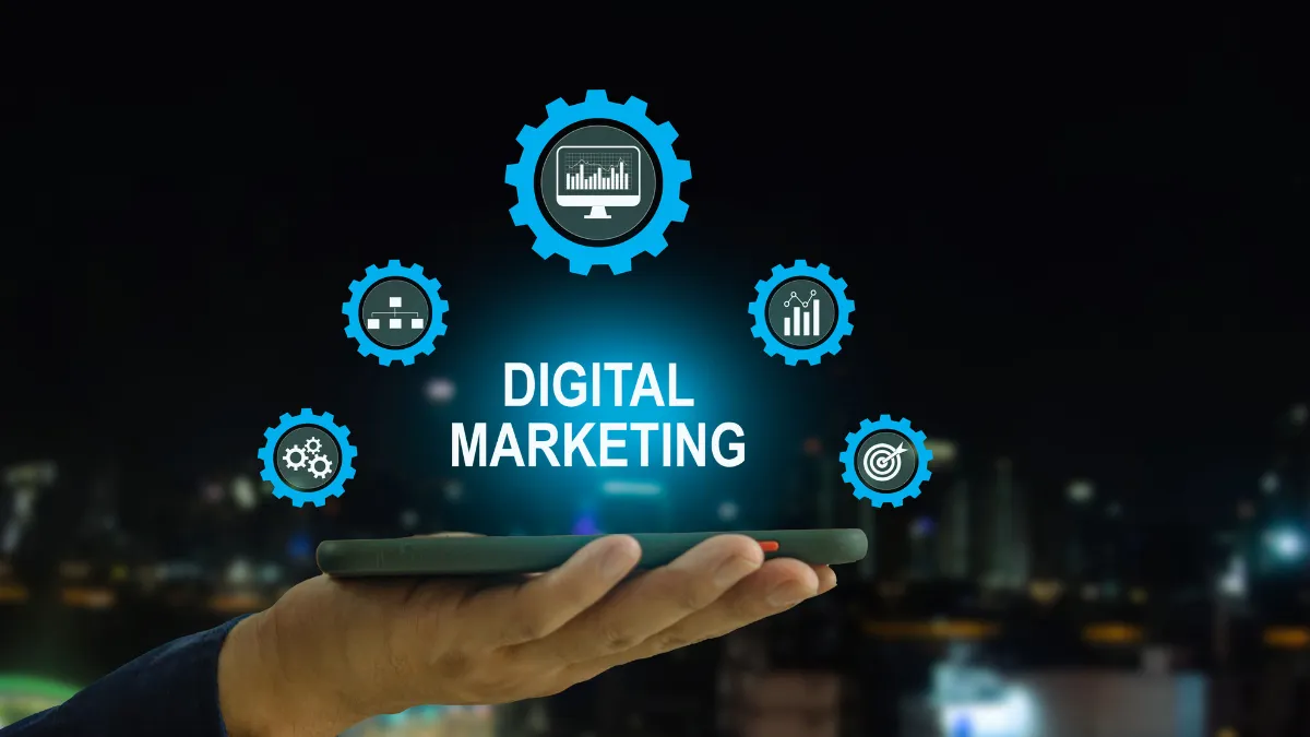 Hand holding a tablet with digital marketing icons and text "DIGITAL MARKETING" surrounded by gears representing web analytics, data management, automation, performance tracking, and targeted marketing.