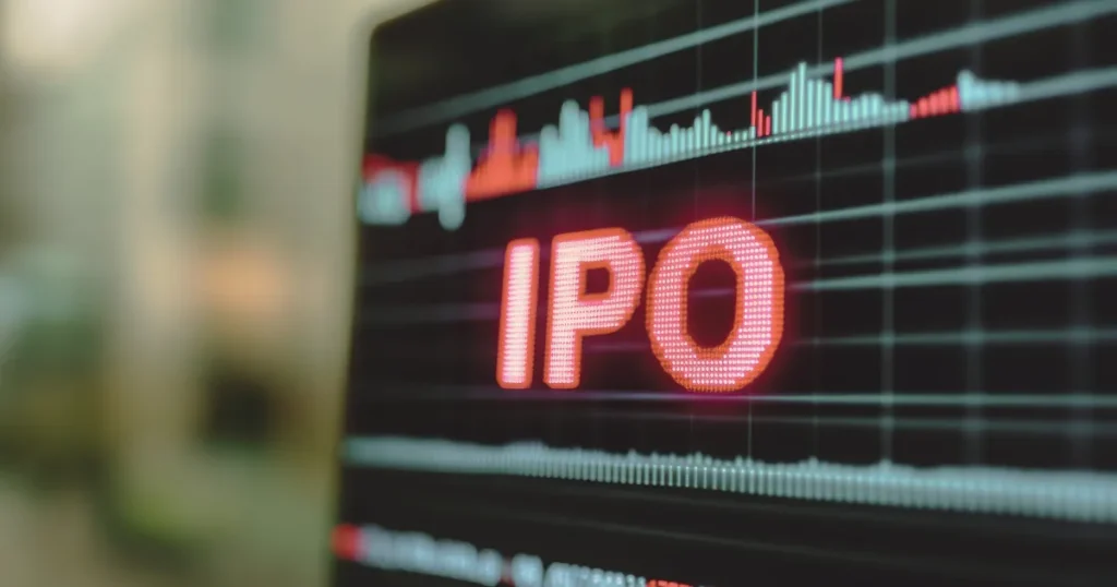 IPO Allotment Status & Market Trends A close-up of a dark digital screen with "IPO" in large, glowing red text, above which are red and white financial charts and graphs indicating market trends.