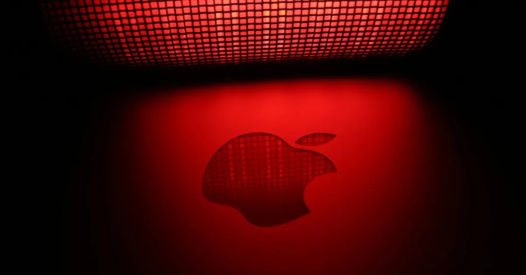 Apple Logo - Illuminated Red Glow A red illuminated Apple logo on a dark background, with a subtle grid pattern visible in the light source above.