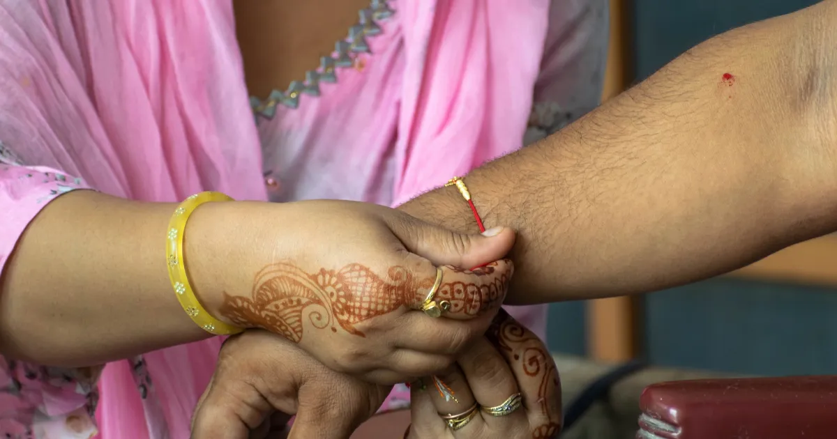 Photo of a Sikh woman tying a rakhi on a man’s wrist, representing the lesser celebration of Raksha Bandhan among most Punjab Sikhs due to unique cultural and religious beliefs.