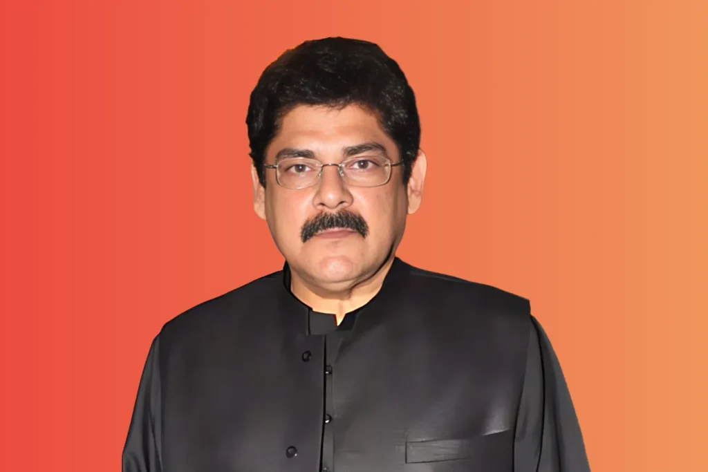 Portrait of a man in elegant black traditional attire, against a warm orange gradient background; a representation of Pankaj Dheer’s legacy and life journey.